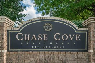 a sign for chase cove apartments on a brick wall