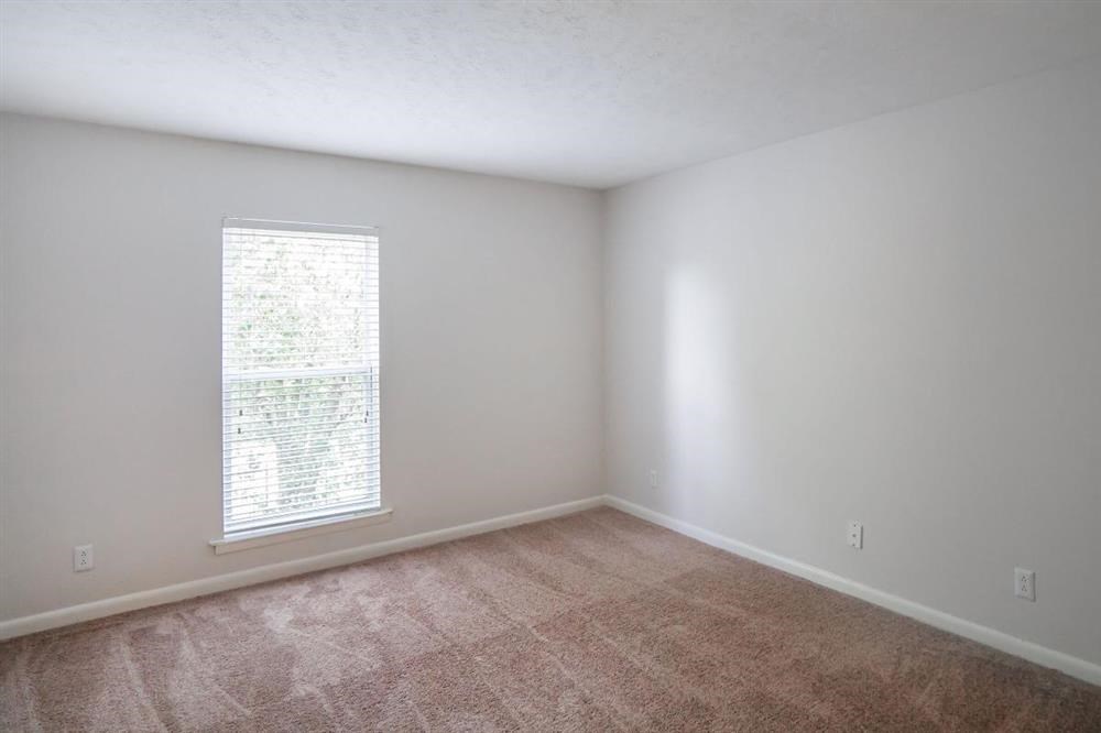 an empty room with carpet and a window