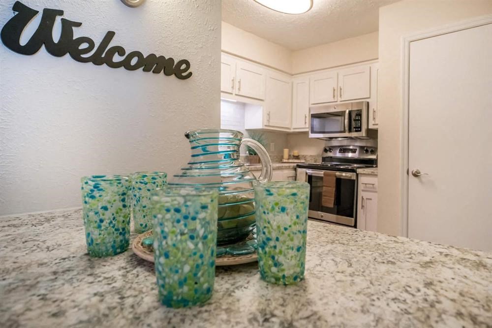 a kitchen with glasses and a vase on a counter