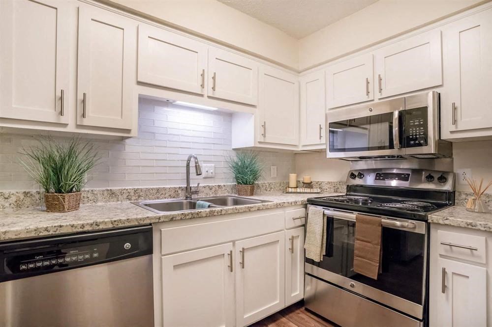a kitchen with stainless steel appliances and white cabinets