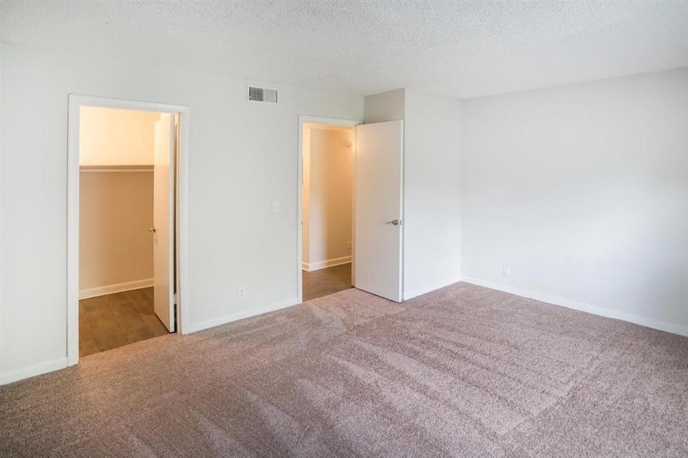 an empty living room with white walls and a carpet
