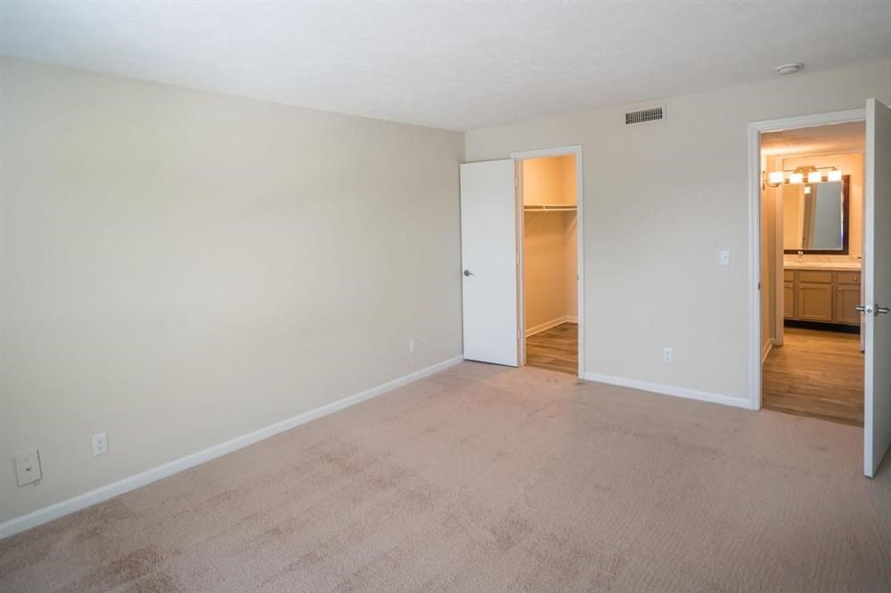 an empty living room with a door to a bathroom