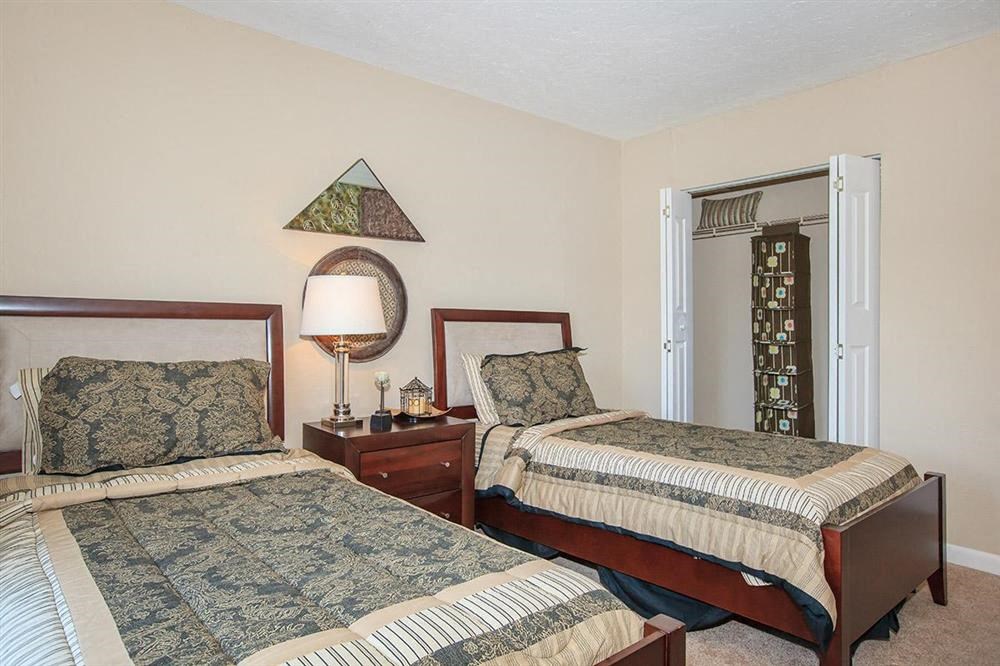 a bedroom with two beds and a night stand