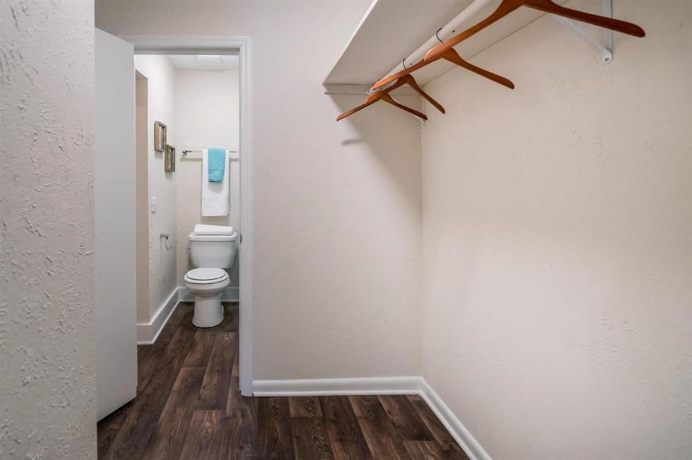 a bathroom with a toilet and a rack on the wall