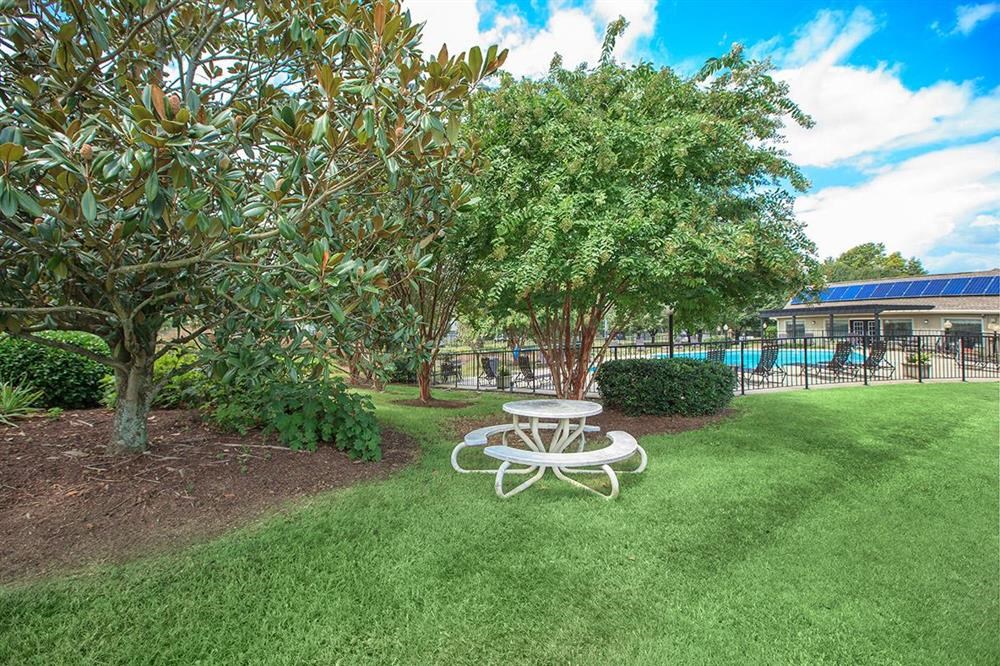 a picnic table in a park next to a pool