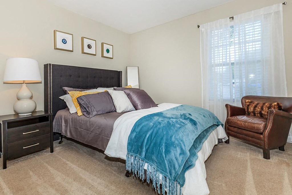 a bedroom with a bed and a chair