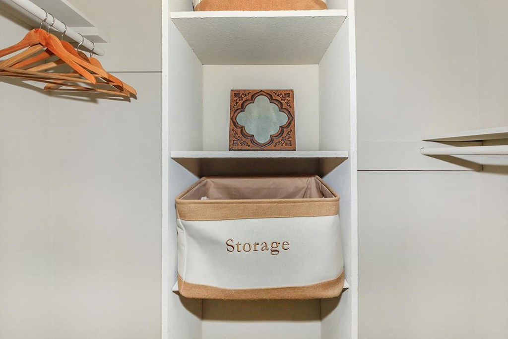 a closet with a storage basket and a shelf