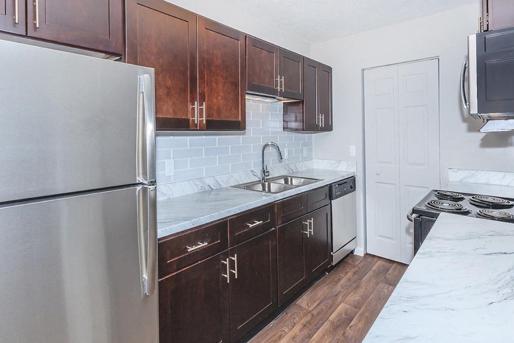 a kitchen with wooden cabinets and a stainless steel refrigerator