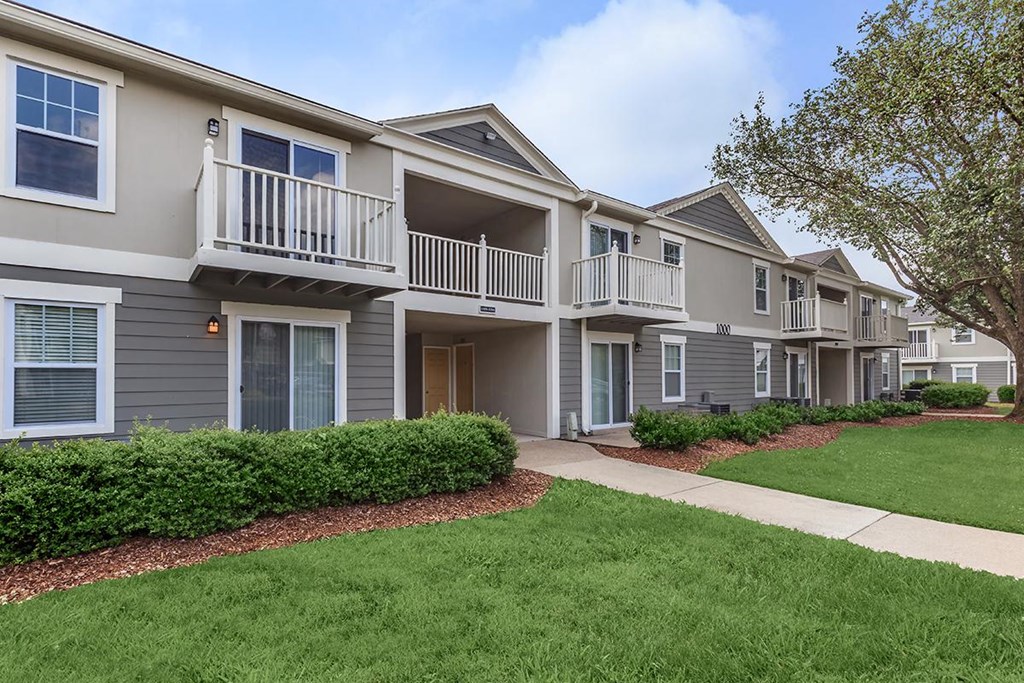 an exterior view of an apartment building with a sidewalk