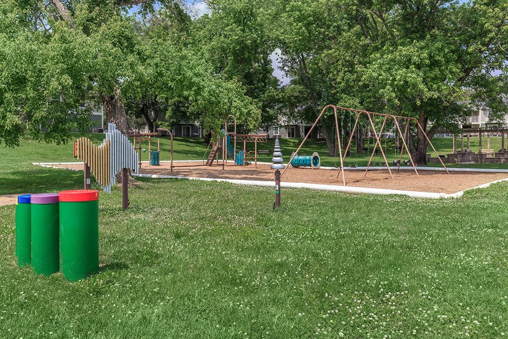 a playground with a swing set in a park