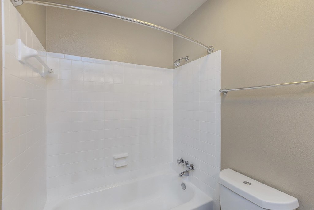 a white bathroom with a shower and a toilet