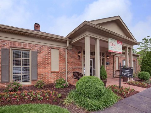 the front of a brick building with a sign in front