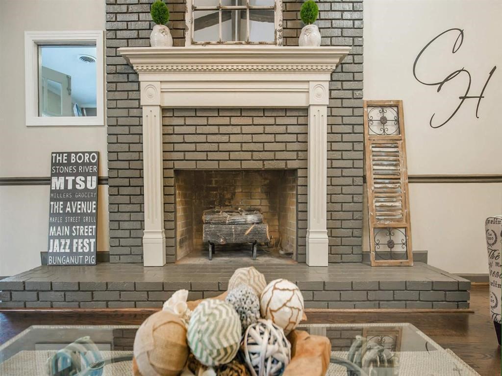 a living room with a fireplace and a table with shells on it