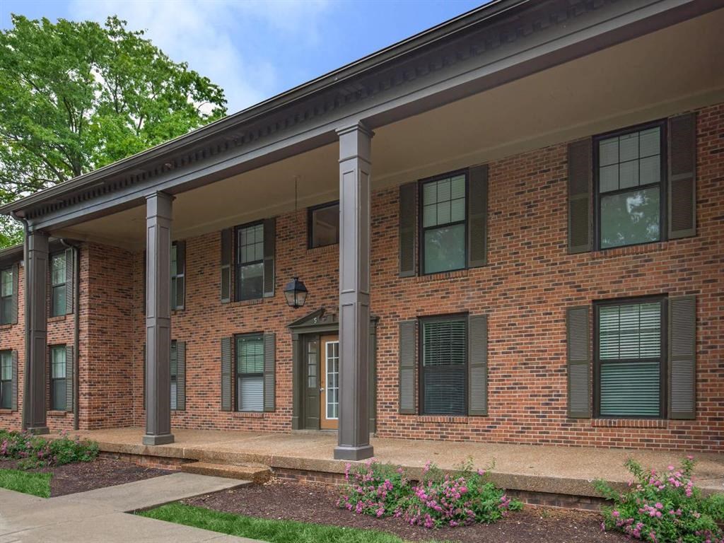 the front of a brick building with columns and a porch