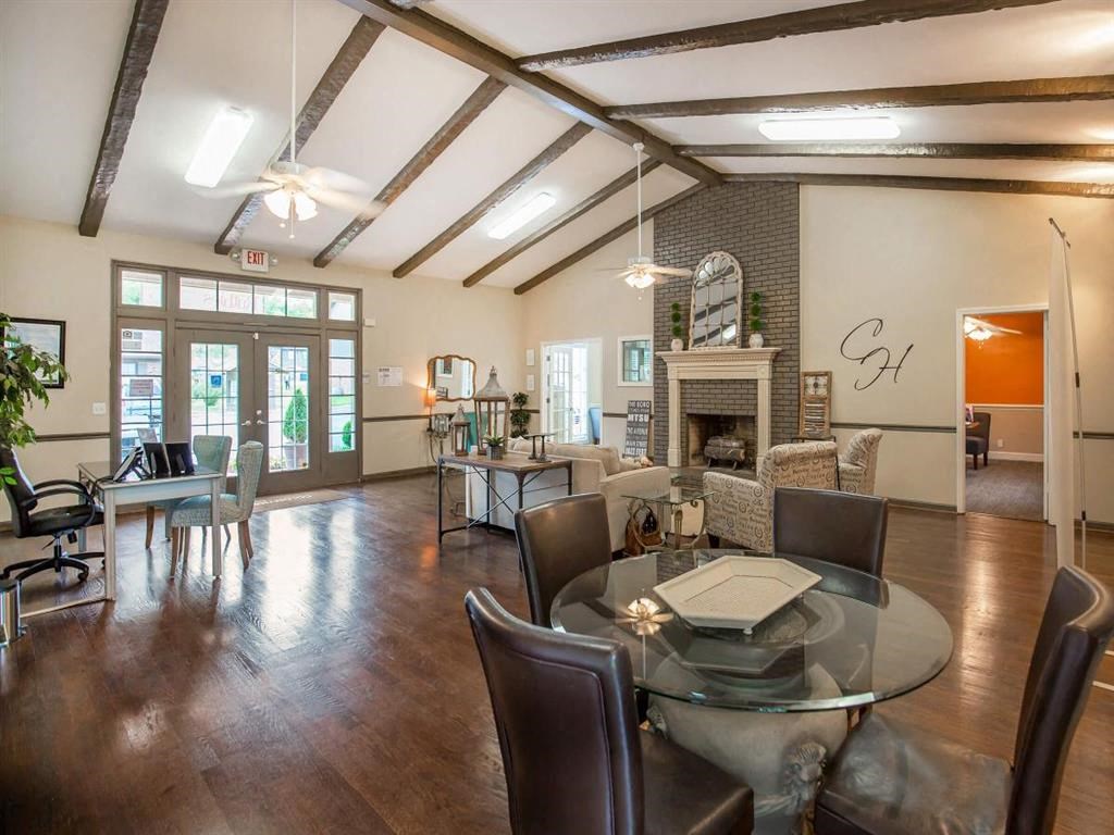 a living room with a glass table and a fireplace