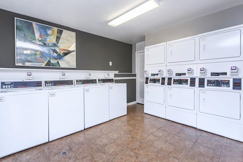 a laundry room with lots of washers and dryers