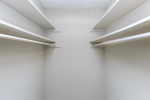 a white room with three white shelves on the wall