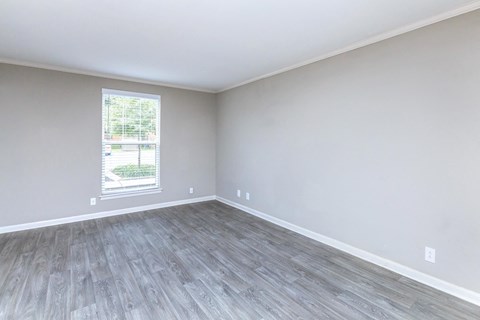 an empty room with wood floors and a window