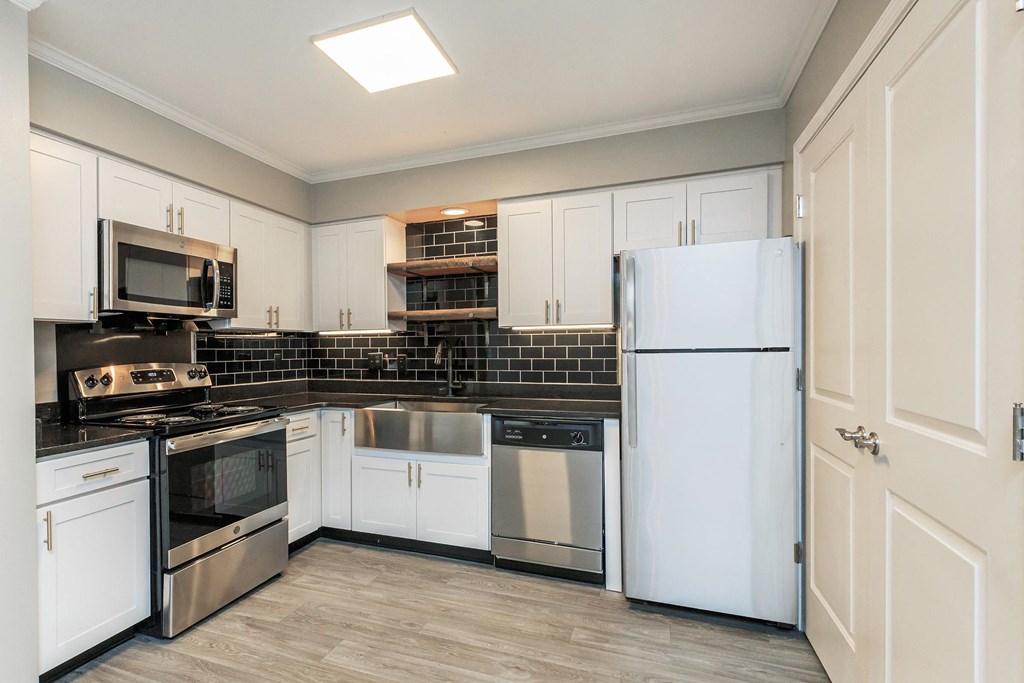 a kitchen with white cabinets and stainless steel appliances