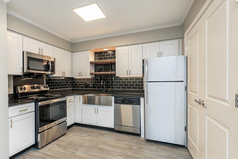 a kitchen with white cabinets and stainless steel appliances