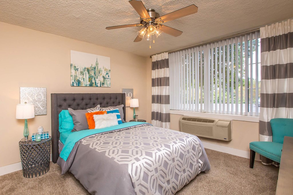 a bedroom with a large bed and a ceiling fan