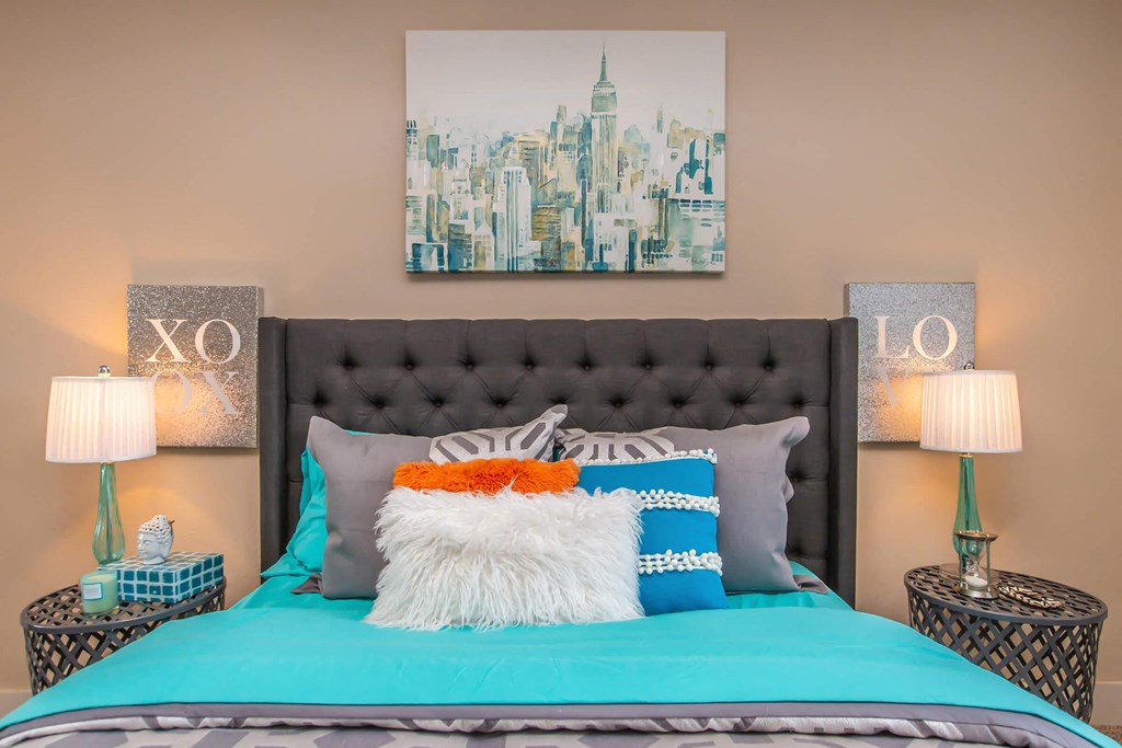 a bedroom with a bed with blue sheets and pillows