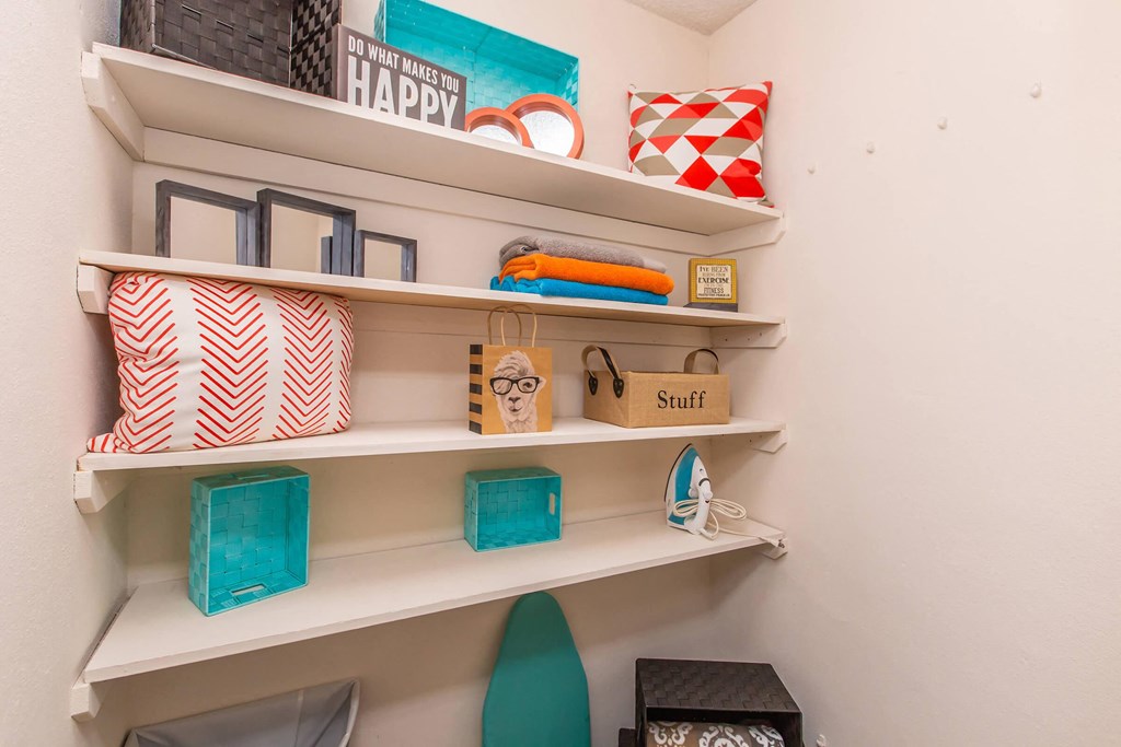 the shelves in the laundry room have baskets and other items on them