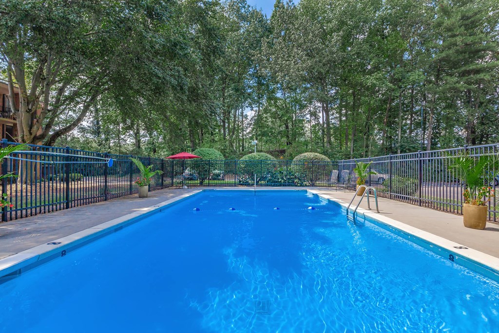 a swimming pool with a fence around it and trees