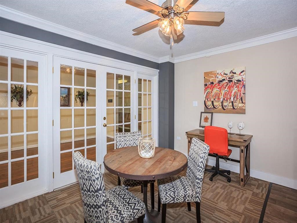 a dining room with a table and chairs and a ceiling fan