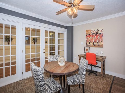 a dining room with a table and chairs and a ceiling fan