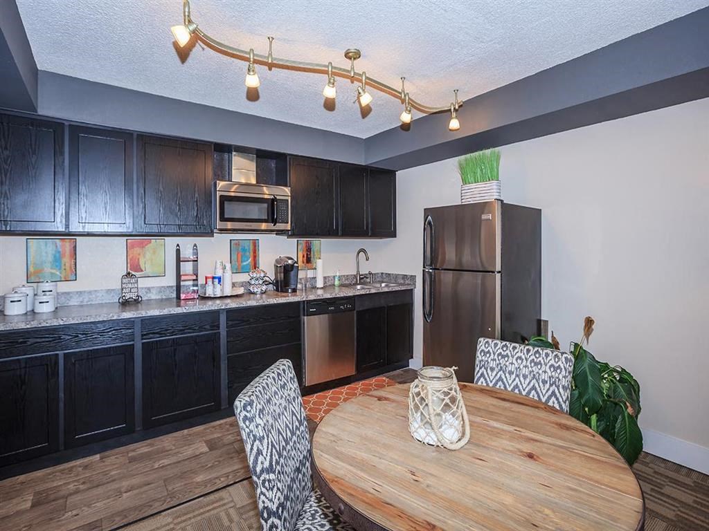 a kitchen with black cabinets and a wooden table