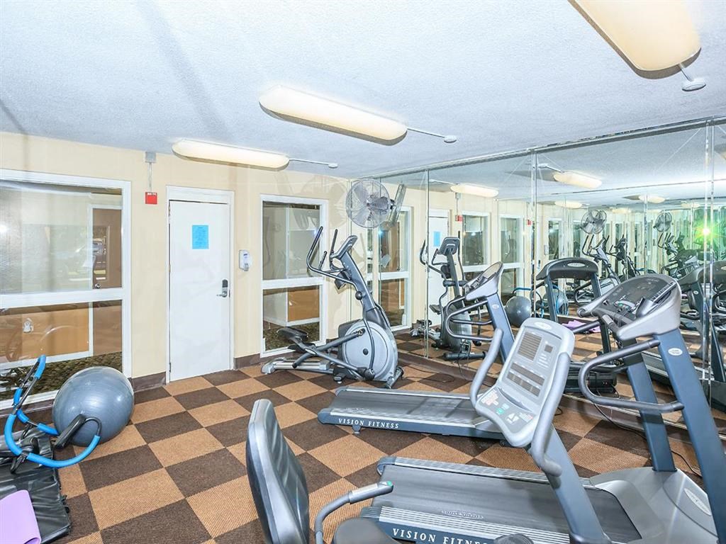 a gym with cardio machines and weights on a checkered floor
