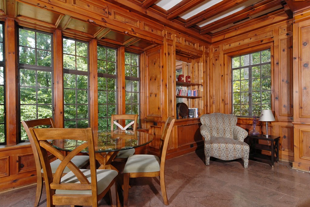 a dining room with wood paneled walls and a glass table and chairs