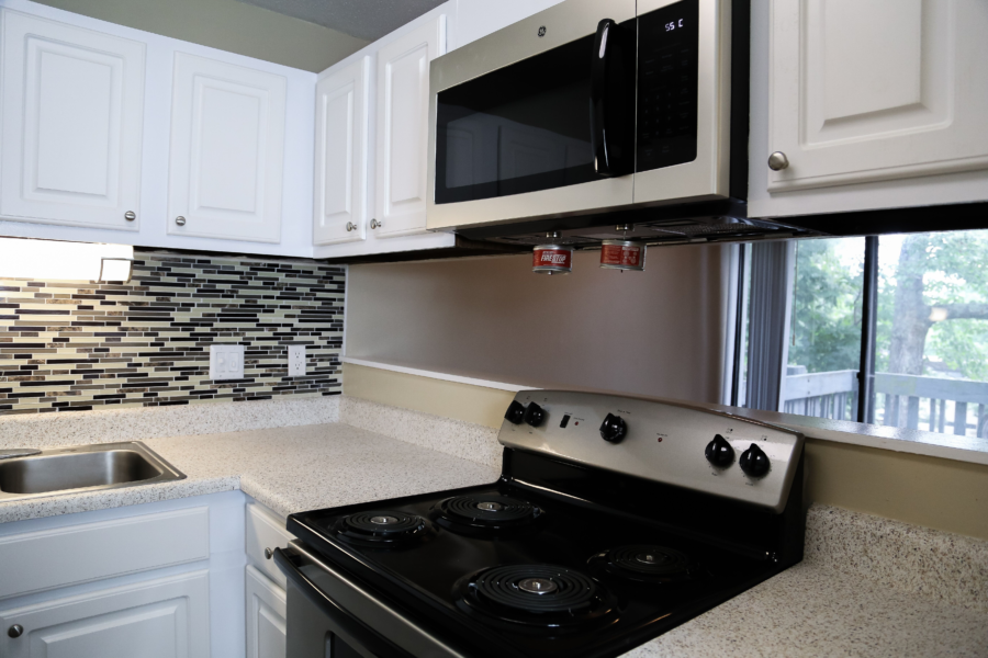 a kitchen with white cabinets and a stove and a microwave