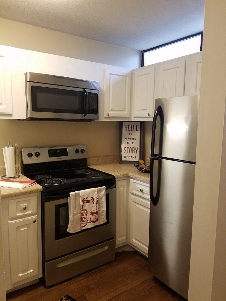 a kitchen with stainless steel appliances and white cabinets