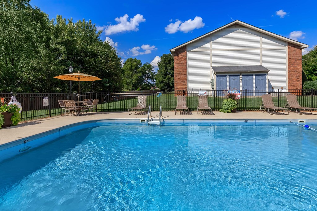 a swimming pool with a house in the background