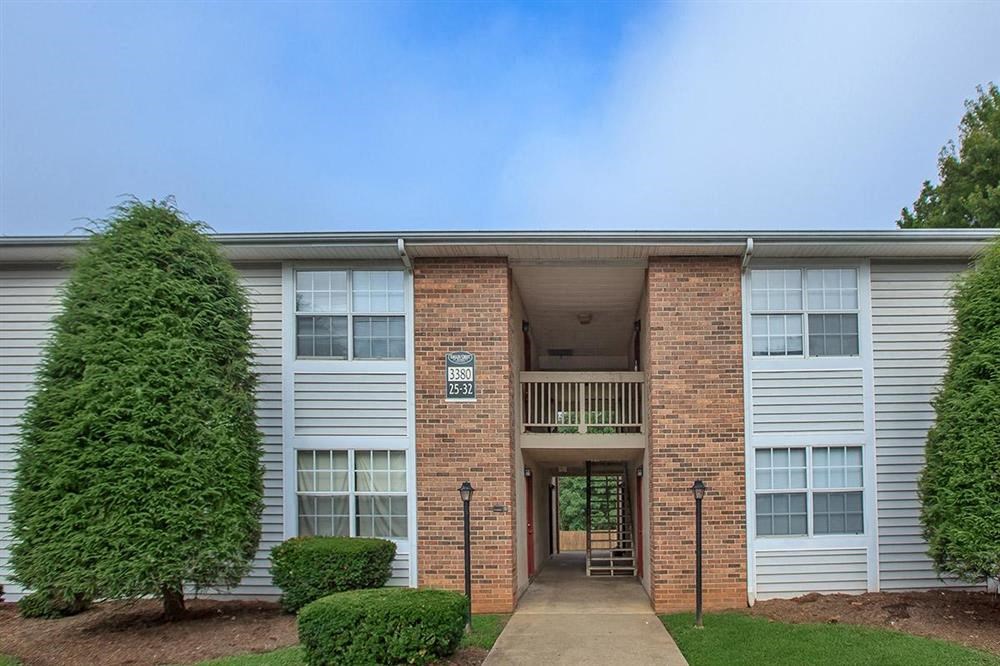 an apartment building with a walkway and a tree