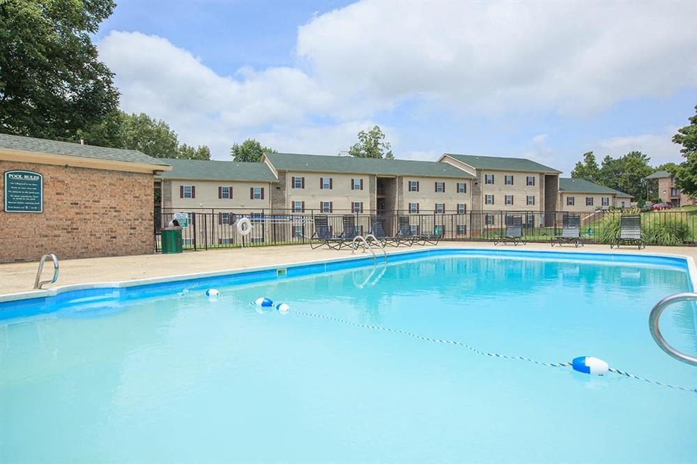 a large swimming pool with an apartment building in the background