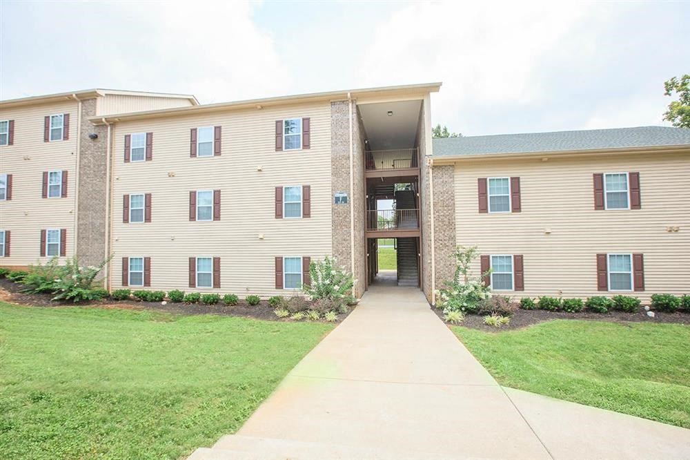 an apartment building with a sidewalk in front of it