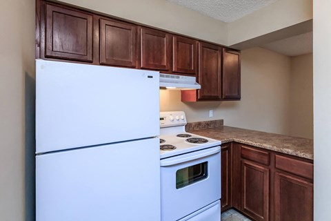 a kitchen with white appliances and brown cabinets