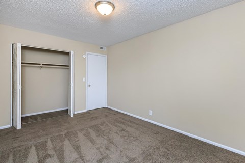 an empty living room with a door to a closet