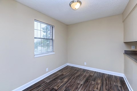 an empty living room with wood flooring and a window