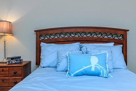 a bed with blue pillows and a wooden headboard