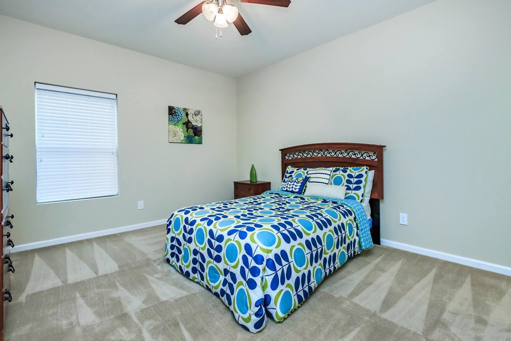 a bedroom with a bed and a ceiling fan