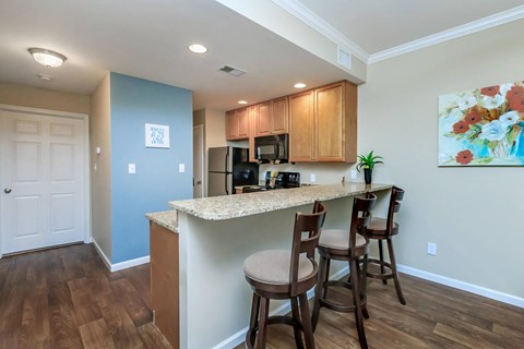 a kitchen with a bar with three stools