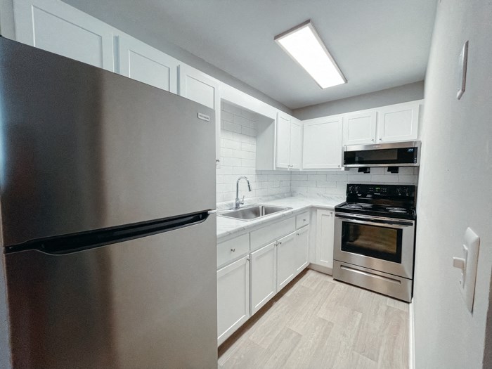 a kitchen with stainless steel appliances and white cabinets
