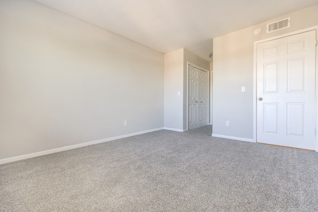 an empty living room with white walls and a white door