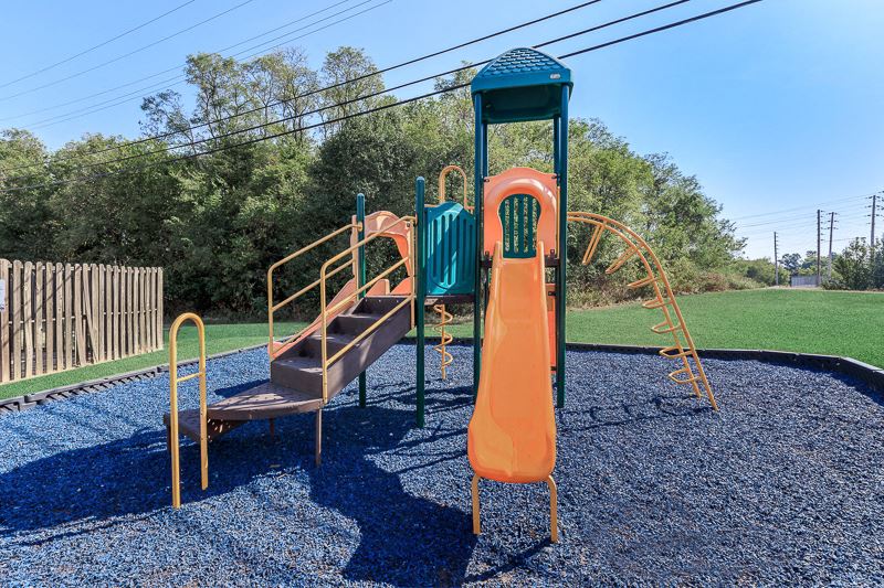 a playground with an orange slide and other playground equipment