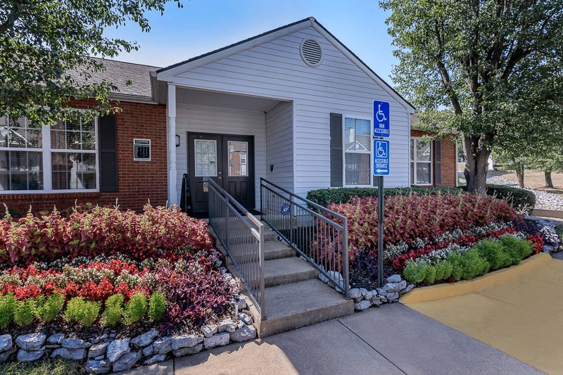 the front of a building with stairs and a sidewalk in front of it