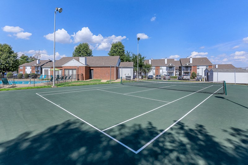 a tennis court with houses in the background